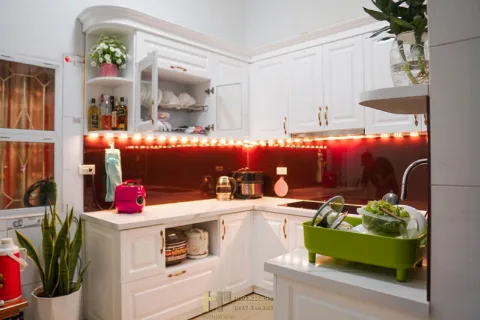 Tủ bếp trắng chữ L ốp kính đỏ